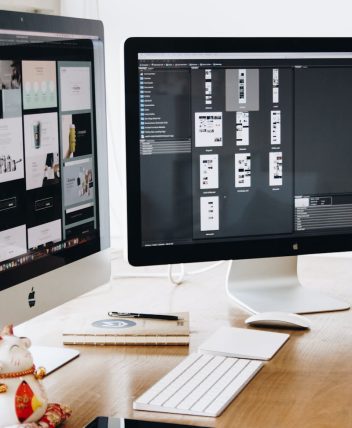 A well-organized design workspace with dual monitors and design software on display.