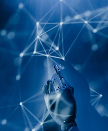 A robotic hand reaching into a digital network on a blue background, symbolizing AI technology.